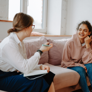 Woman and young person on sofa talking